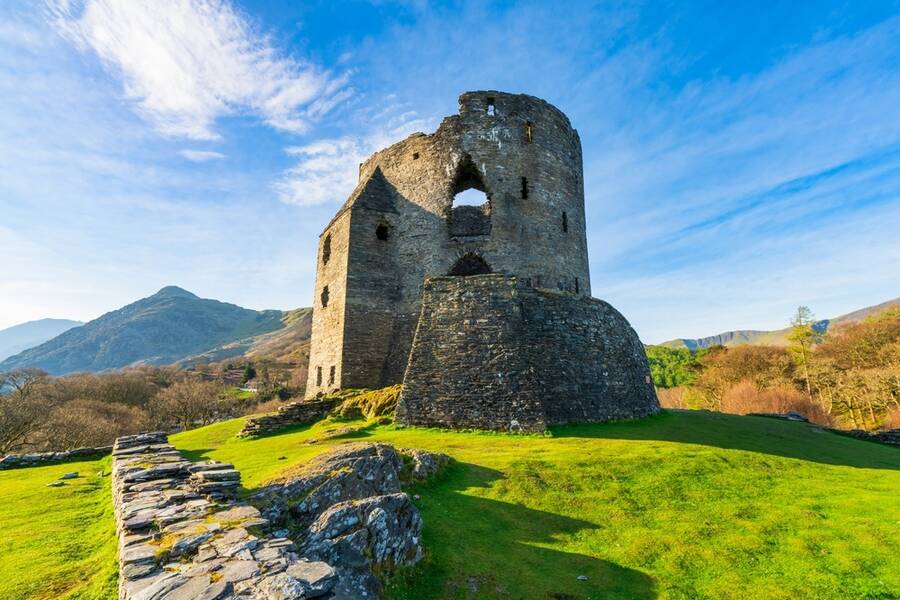Dolbadarn Castle ruins overlooking Llanberis with mountains of Snowdonia in the background.