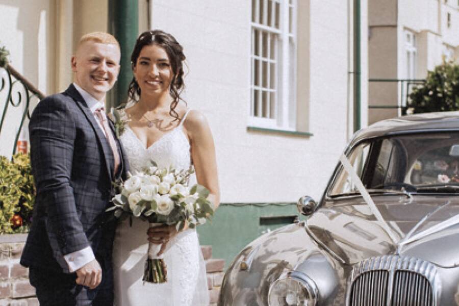 Bride and groom posing in The Royal Victoria Hotel gardens.